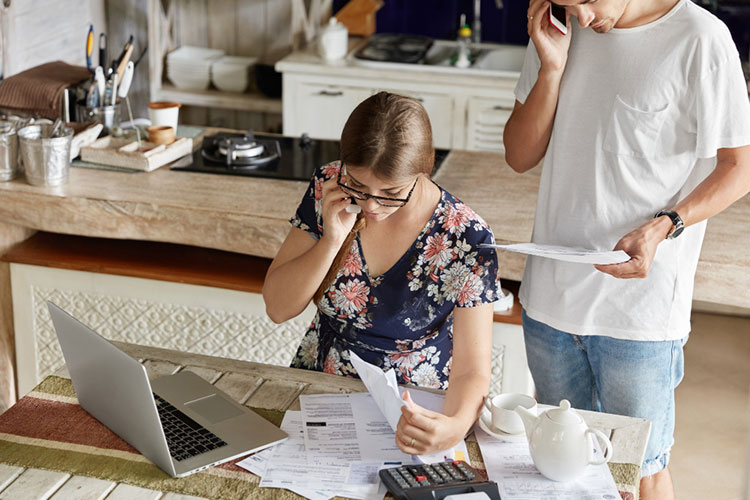 Couple managing budget together in kitchen