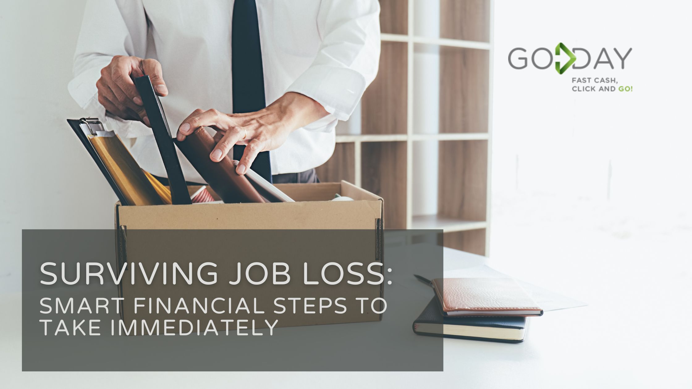 Man in business attire packing office items into a cardboard box, symbolizing job loss, with overlay text “Surviving Job Loss: Smart Financial Steps to Take Immediately” from GoDay.